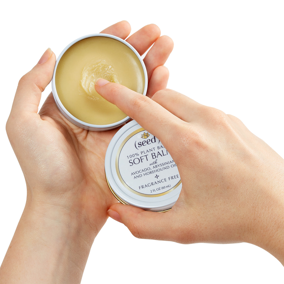 Seed Soft Balm in use, open lid, shown in fragrance free 2 oz tin